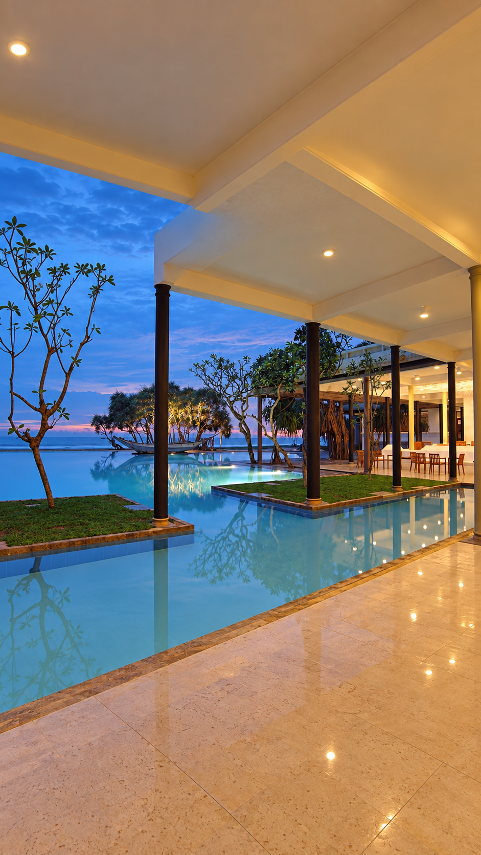 A beachfront pool and pavilion overlooking the ocean at dusk